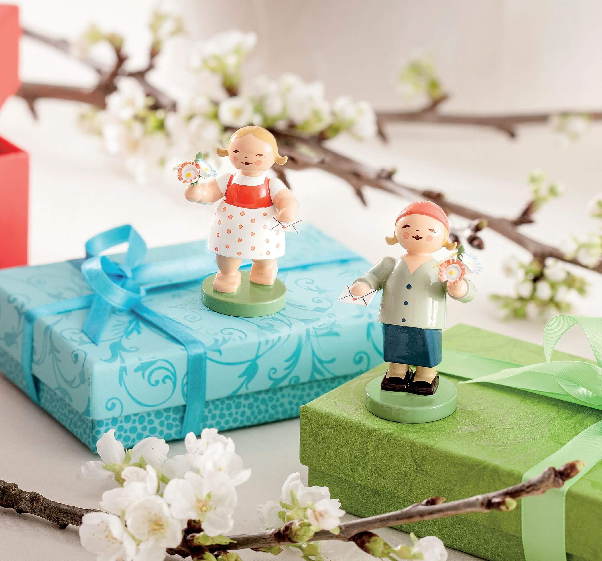 Moodbild Wendt & Kühn Blumenmädchen auf Geschenkboxen.