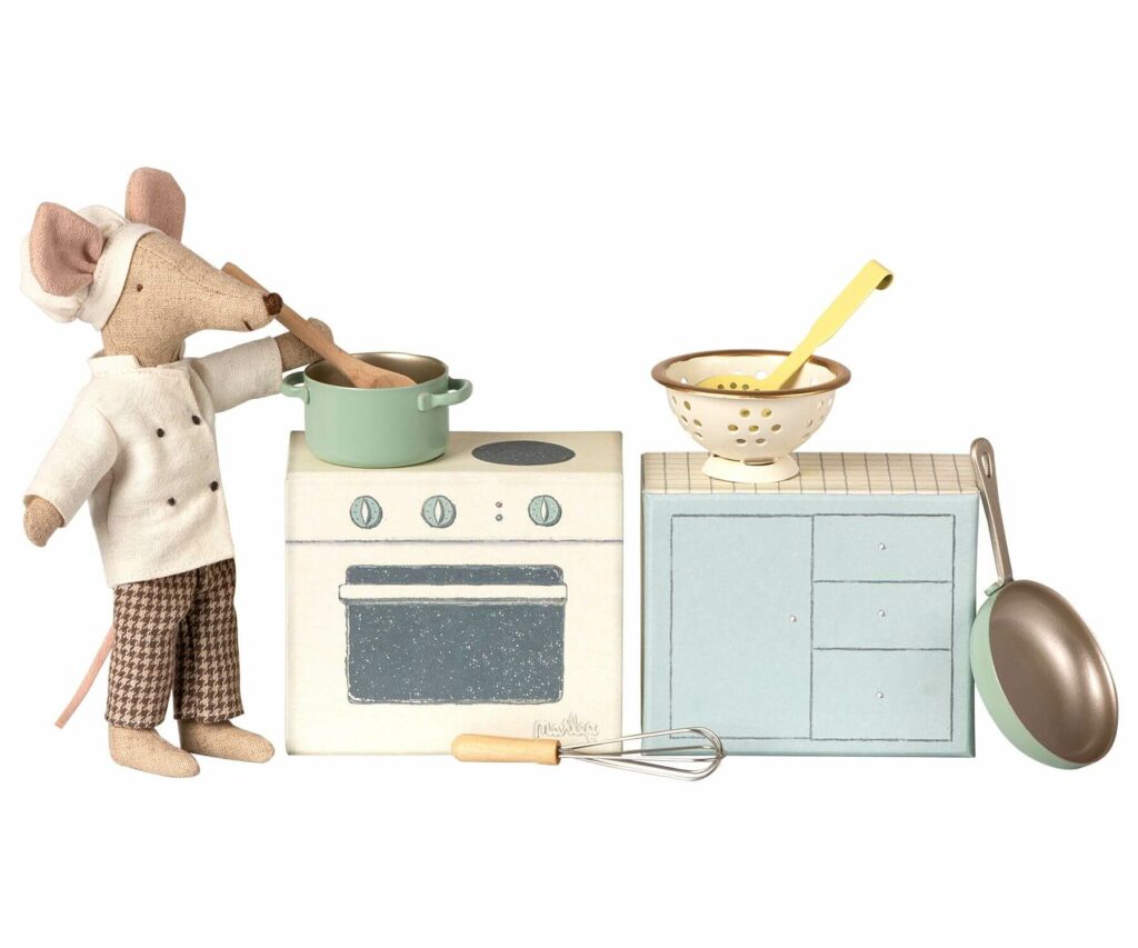Freisteller eines Küchensets bestehend aus Ofen, Topf, Pfanne, Sieb, Löffel, Schaumkelle und Schneebesen in Pastelltönen für Puppenhäuser.